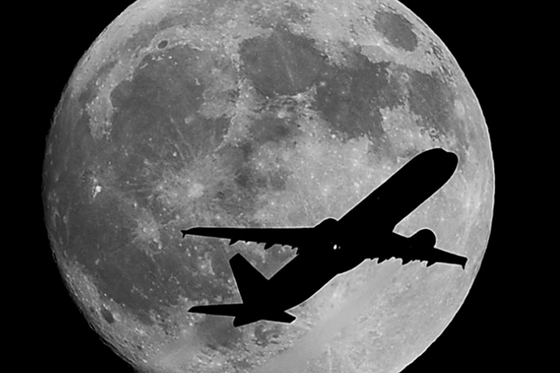 Nick Ut captures a silhouette of an airplane as it passes over the moon