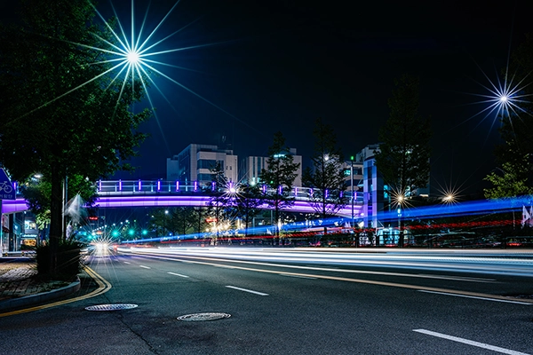 A city street at night made vibrant using long exposure photography to create dynamic streaks of light.