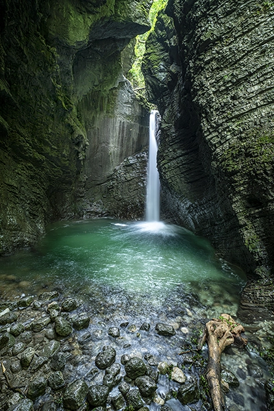 A waterfall cascading down between tall cliffs showing an example of a long exposure shot