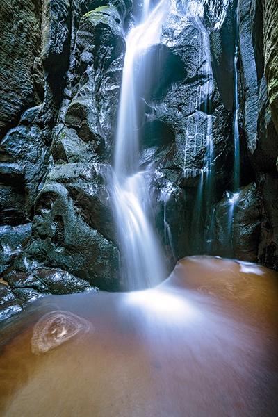 A waterfall cascading down a cliff using long exposure photography to smooth out the water